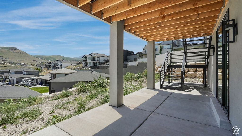 View of patio / terrace with a residential view, stairs, and a mountain view
