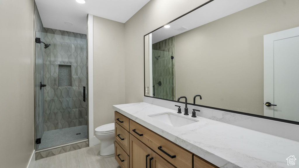 Full bathroom featuring vanity, a shower stall, and recessed lighting