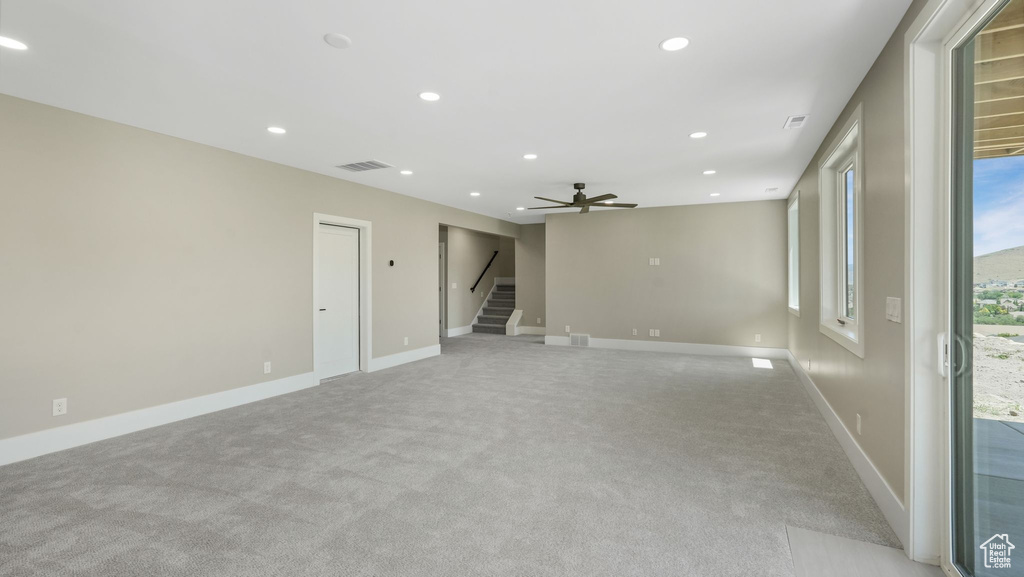 Spare room featuring stairway, light colored carpet, recessed lighting, and ceiling fan