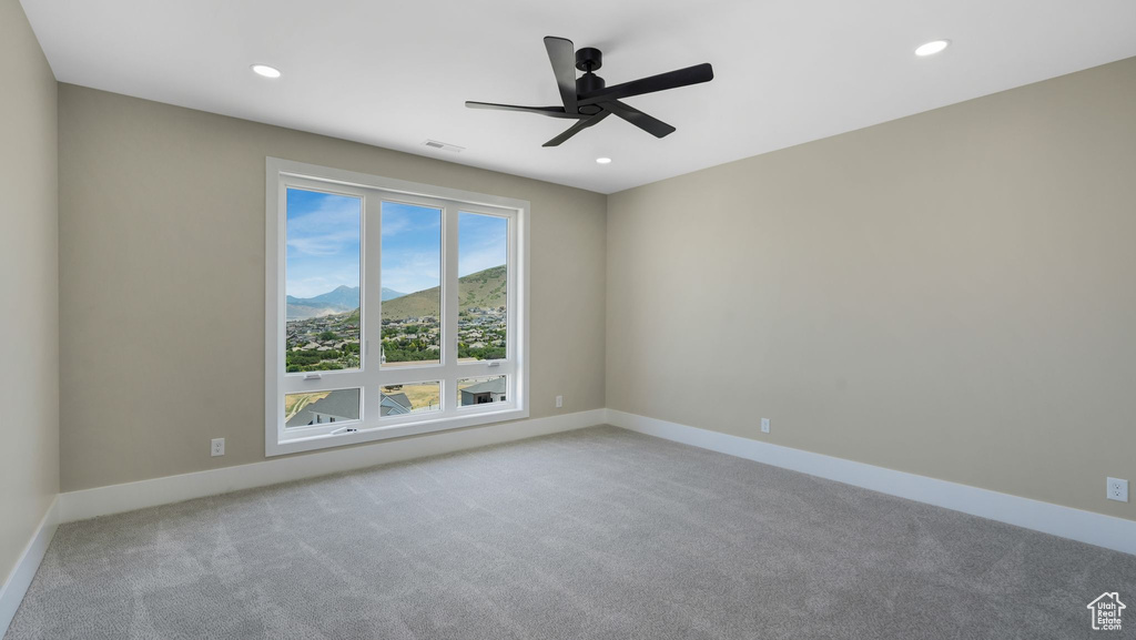 Carpeted spare room featuring a mountain view, a ceiling fan, and recessed lighting