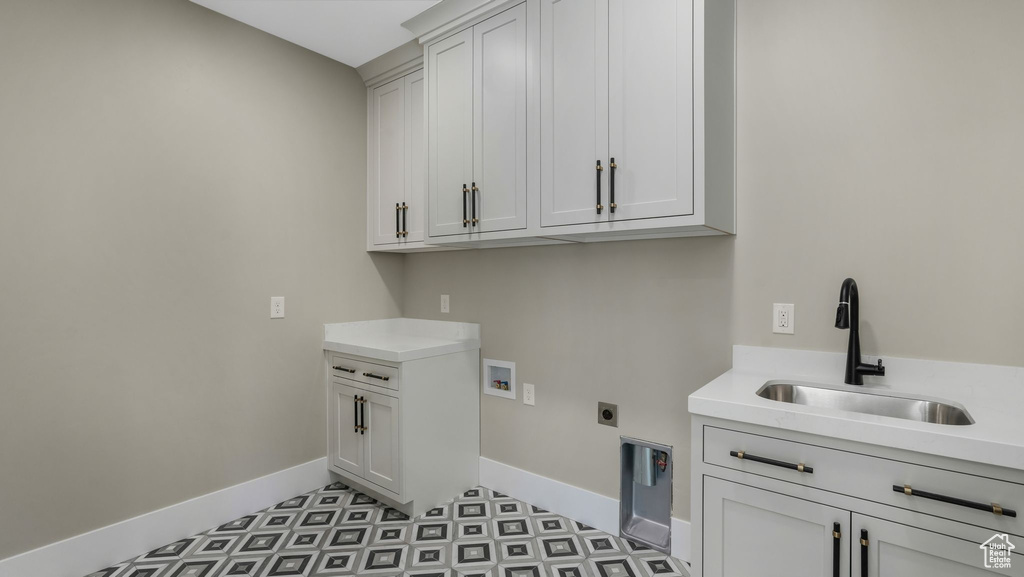 Laundry room with cabinet space, washer hookup, hookup for an electric dryer, and light flooring
