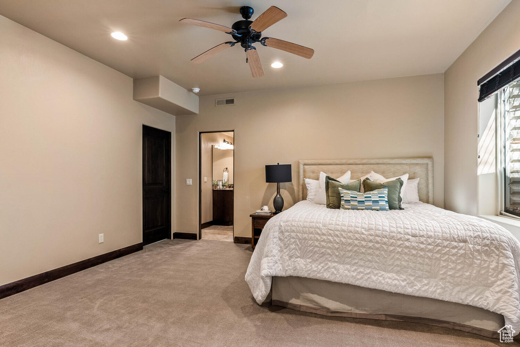 Bedroom with light colored carpet, recessed lighting, ensuite bath, and a ceiling fan