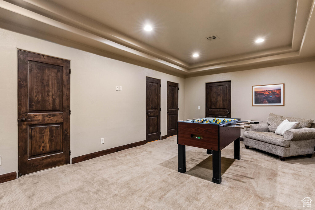 Game room with light carpet, a tray ceiling, and recessed lighting
