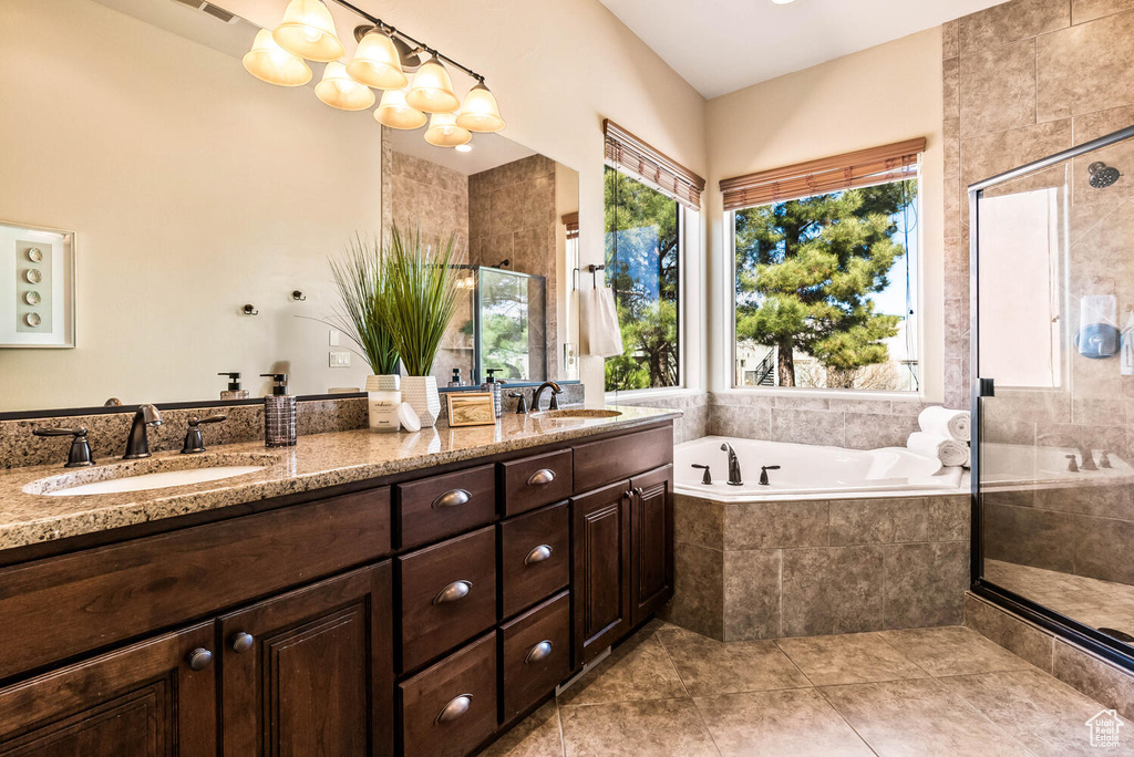 Bathroom with a bath, double vanity, a shower stall, and tile patterned flooring