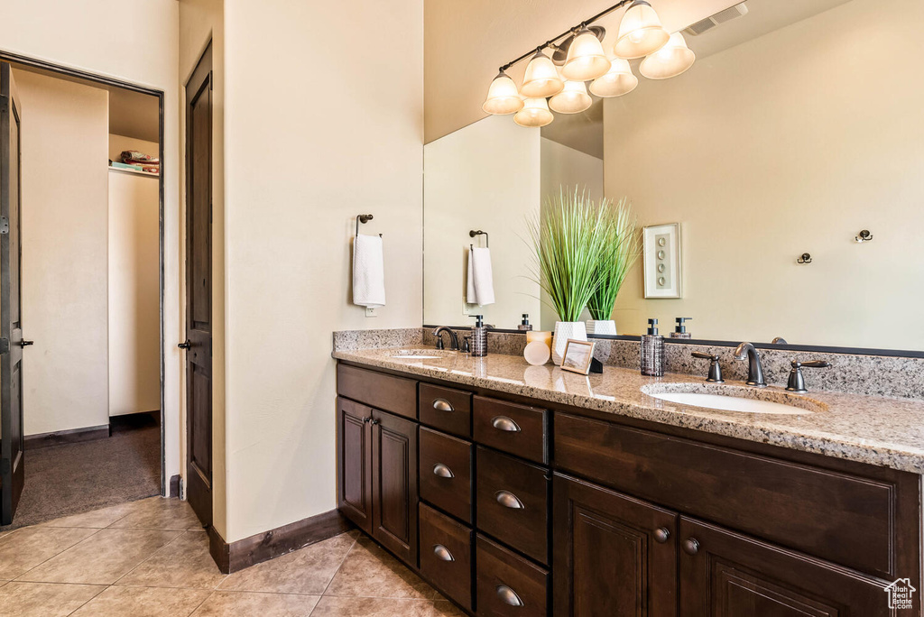 Bathroom with double vanity and tile patterned flooring