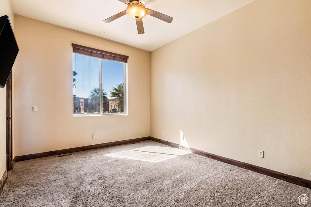 Spare room with carpet floors and a ceiling fan