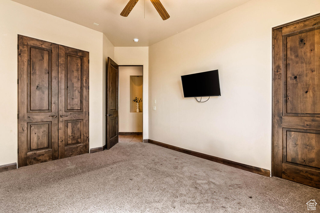 Unfurnished bedroom with carpet flooring and a ceiling fan
