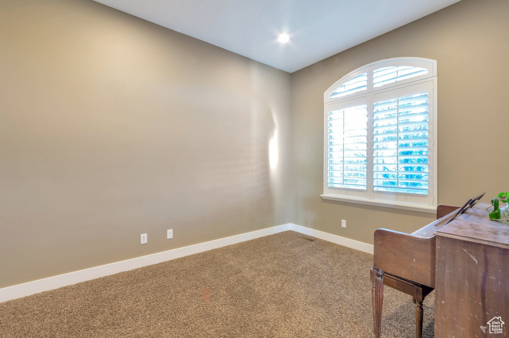 Carpeted home office featuring baseboards