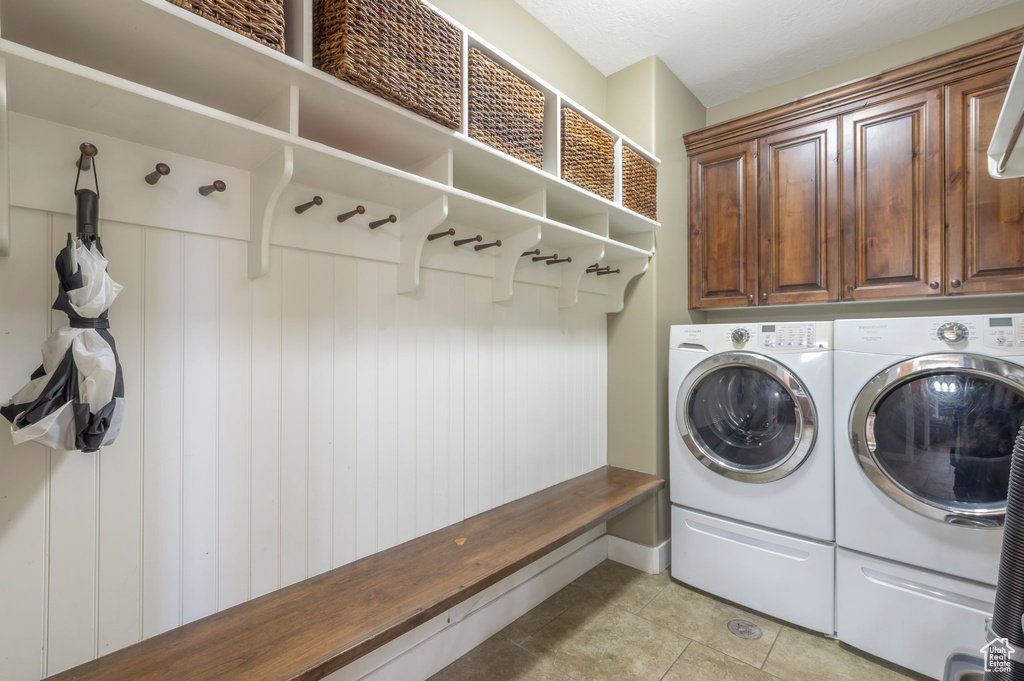Washroom with separate washer and dryer, cabinet space, and light tile patterned floors