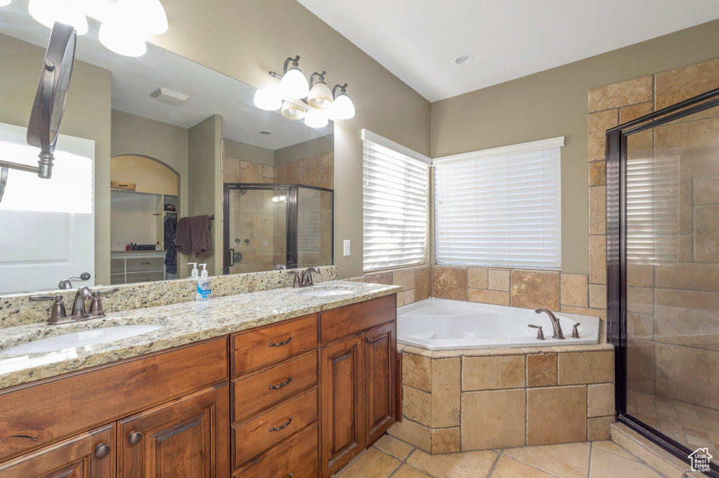 Full bathroom featuring a shower stall, double vanity, a bath, and tile patterned flooring