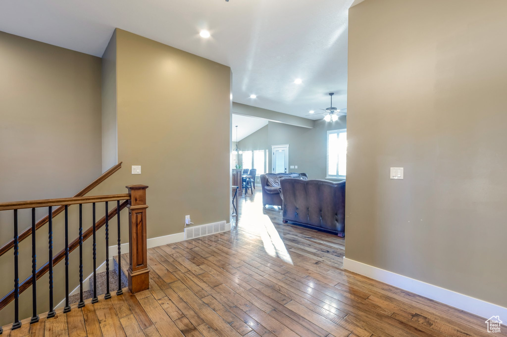 Hallway with hardwood / wood-style flooring, recessed lighting, an upstairs landing, and lofted ceiling