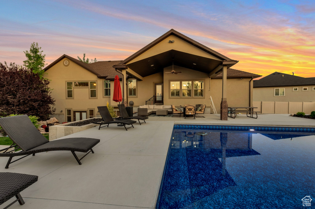 Rear view of house featuring an outdoor hangout area, a ceiling fan, stucco siding, a patio, and an outdoor pool