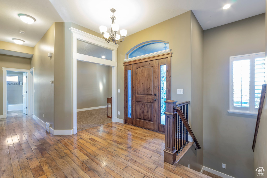 Entrance foyer with hardwood / wood-style flooring and a chandelier