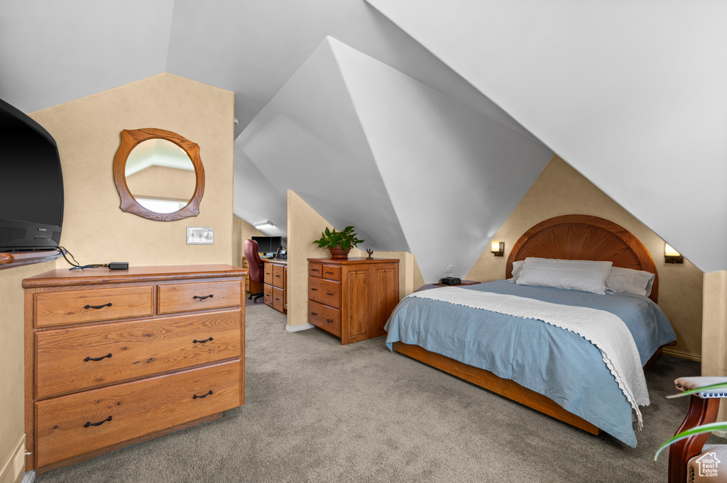 Bedroom with light carpet and vaulted ceiling