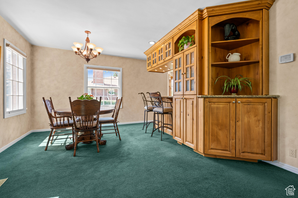 Dining room featuring a chandelier and dark carpet