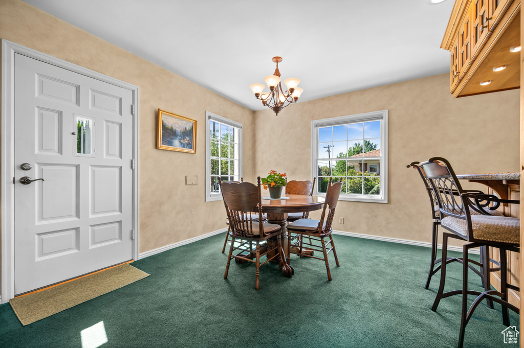 Dining room featuring a chandelier and dark colored carpet