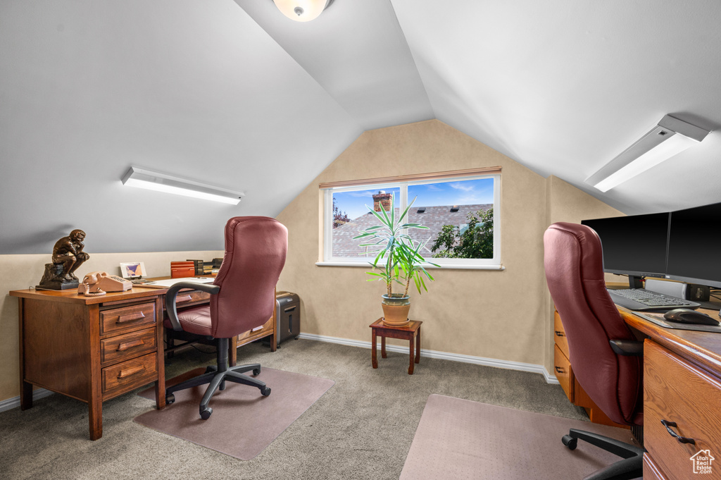 Carpeted office featuring vaulted ceiling and baseboards
