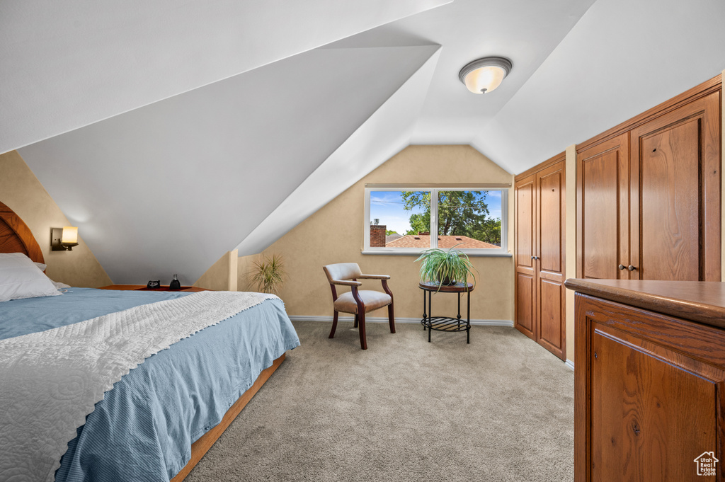 Bedroom featuring vaulted ceiling and light colored carpet