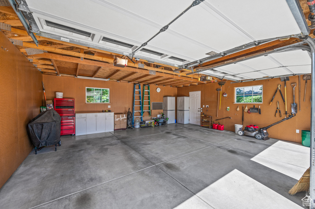 Garage featuring a garage door opener and freestanding refrigerator