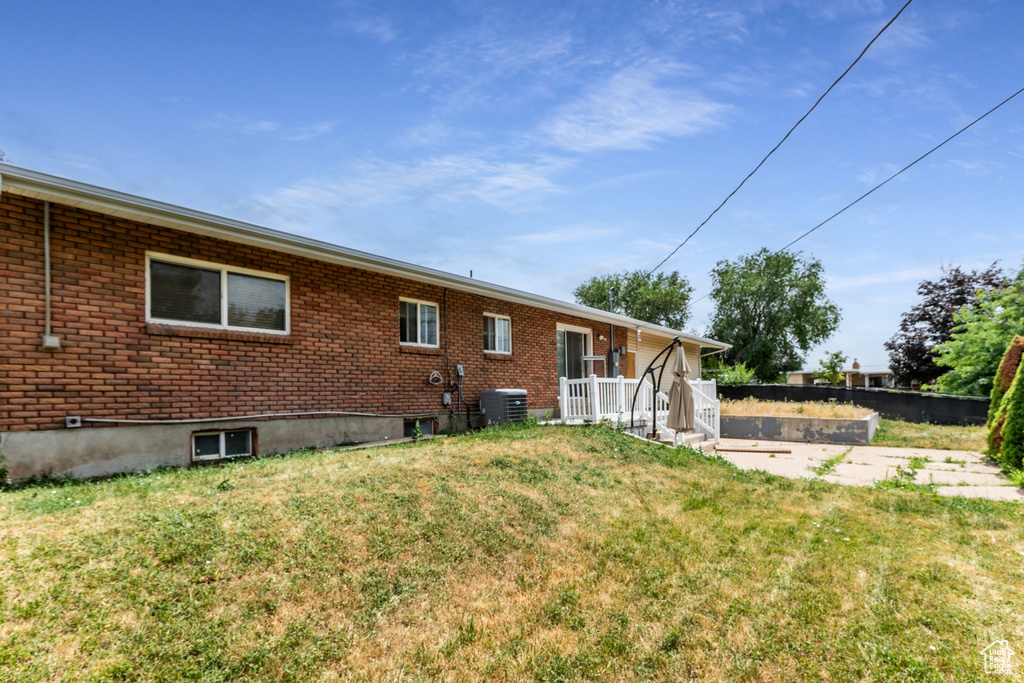 Back of property featuring a yard and brick siding