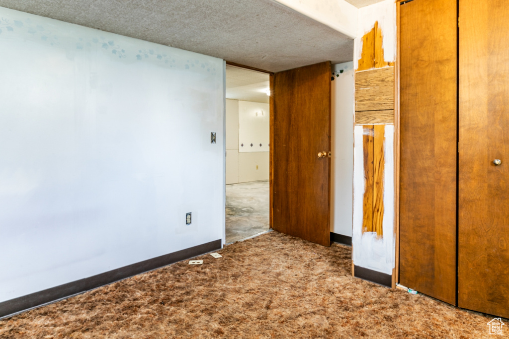 Unfurnished bedroom featuring carpet floors, a closet, and a textured ceiling