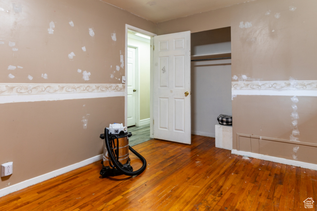 Unfurnished bedroom with hardwood / wood-style flooring and a closet