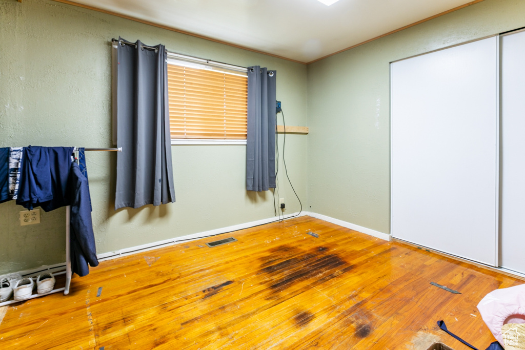 Unfurnished bedroom with wood finished floors and crown molding