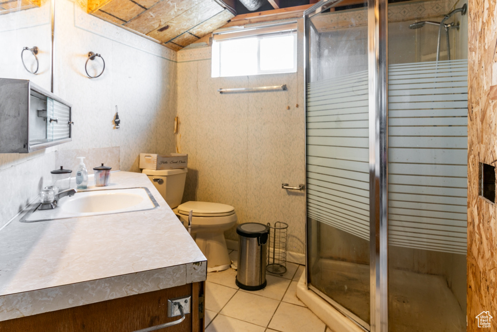 Full bathroom with vanity, a stall shower, tile patterned floors, and lofted ceiling