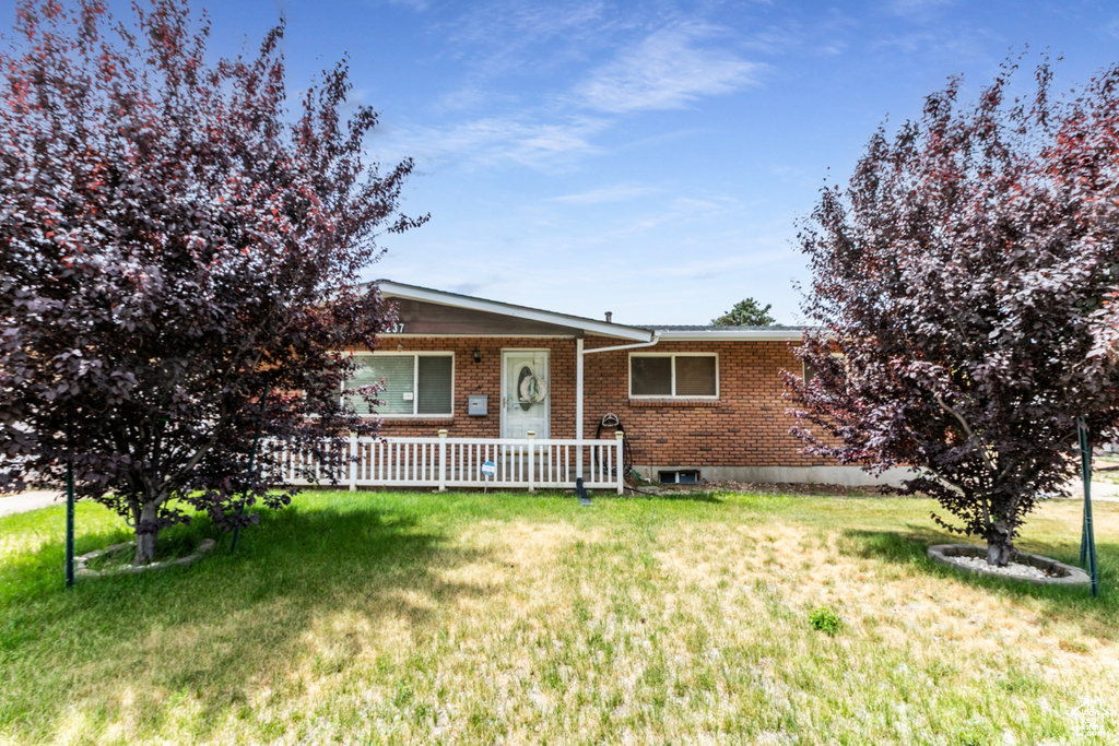 Single story home with brick siding, a front lawn, and a porch