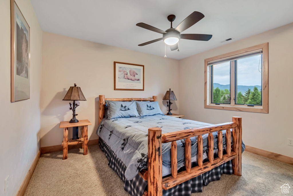 Carpeted bedroom with baseboards and a ceiling fan