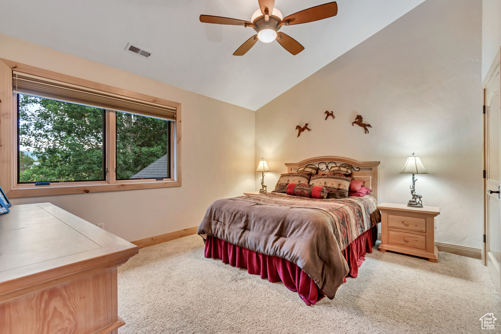 Bedroom with light carpet, vaulted ceiling, and a ceiling fan