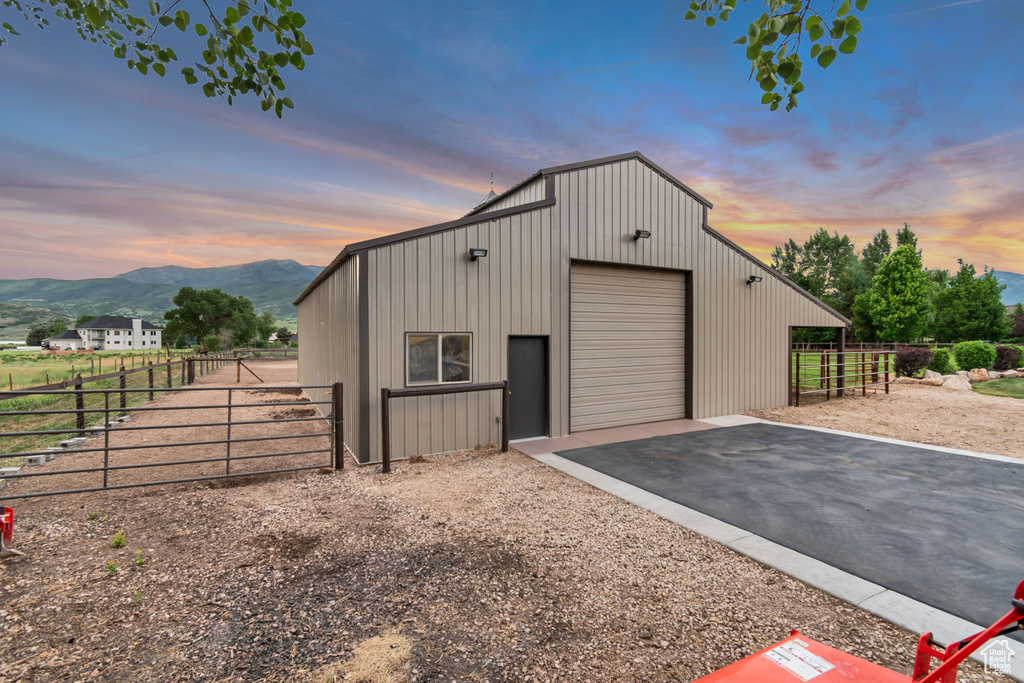 Outdoor structure at dusk featuring driveway and a mountain view