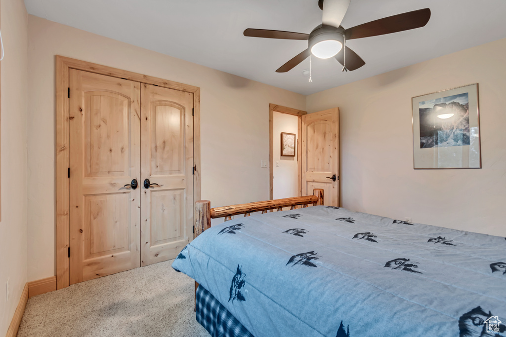 Carpeted bedroom featuring a ceiling fan