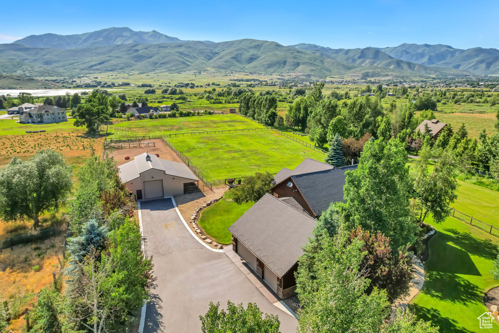 Aerial view of property and surrounding area with a mountainous background