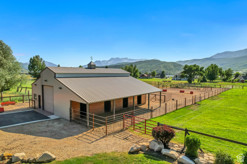Horse barn featuring a mountain view and a view of countryside
