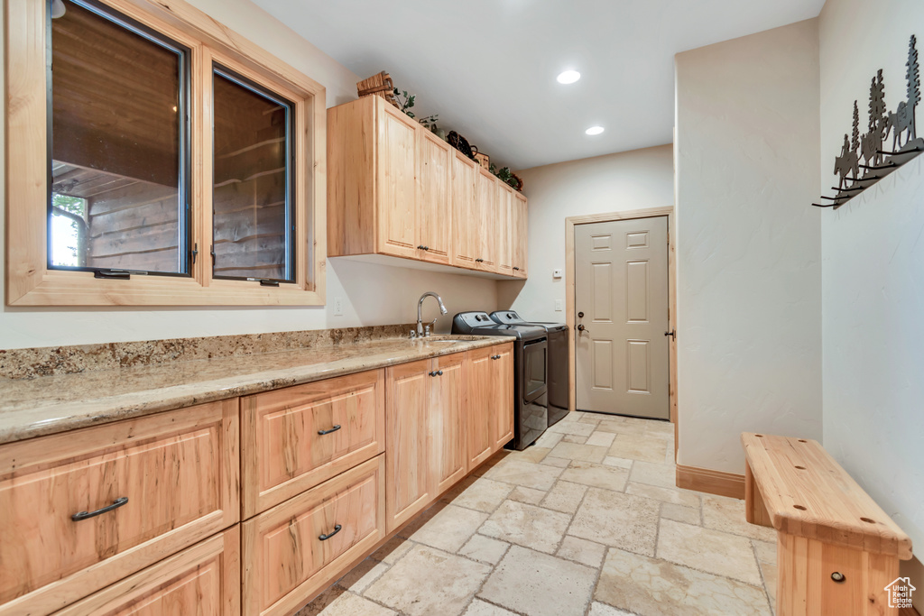 Washroom featuring separate washer and dryer, stone tile floors, recessed lighting, and cabinet space