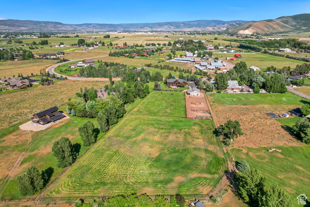 Aerial view of property and surrounding area featuring rural landscape and a mountainous background