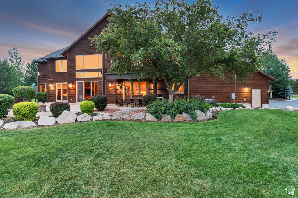 Back of property featuring a lawn and a patio