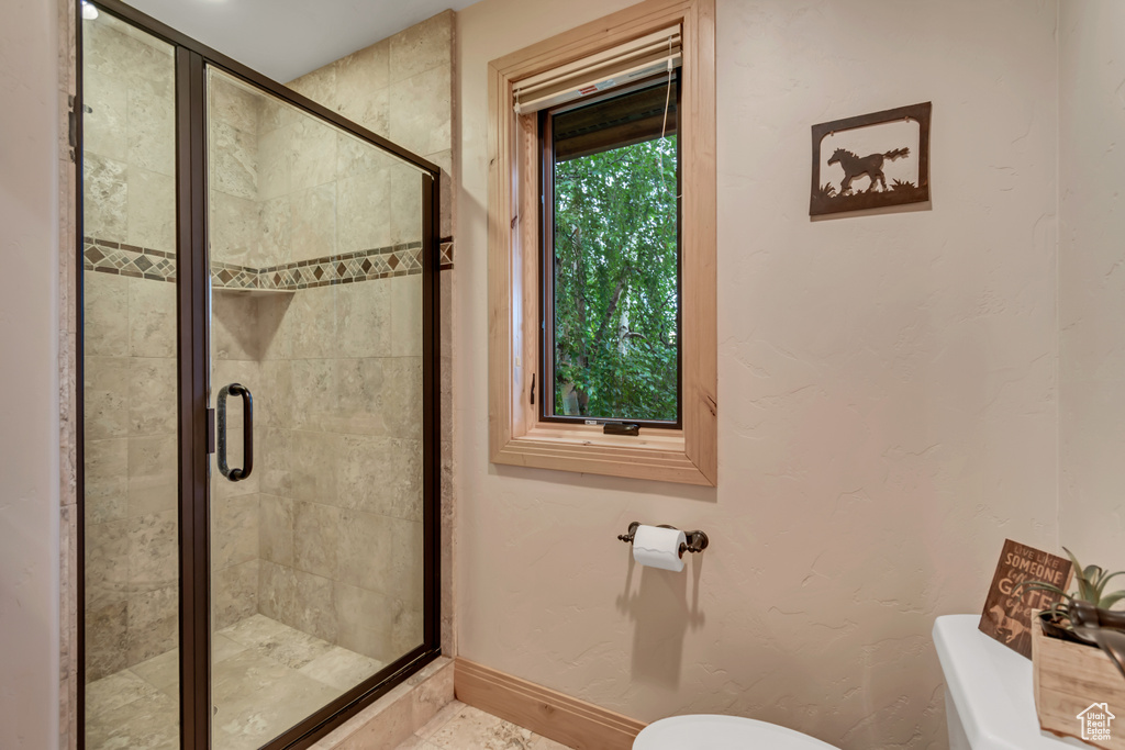 Full bathroom with toilet and a stall shower