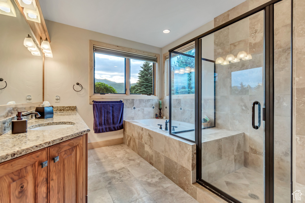 Full bathroom with vanity, a garden tub, and a shower stall