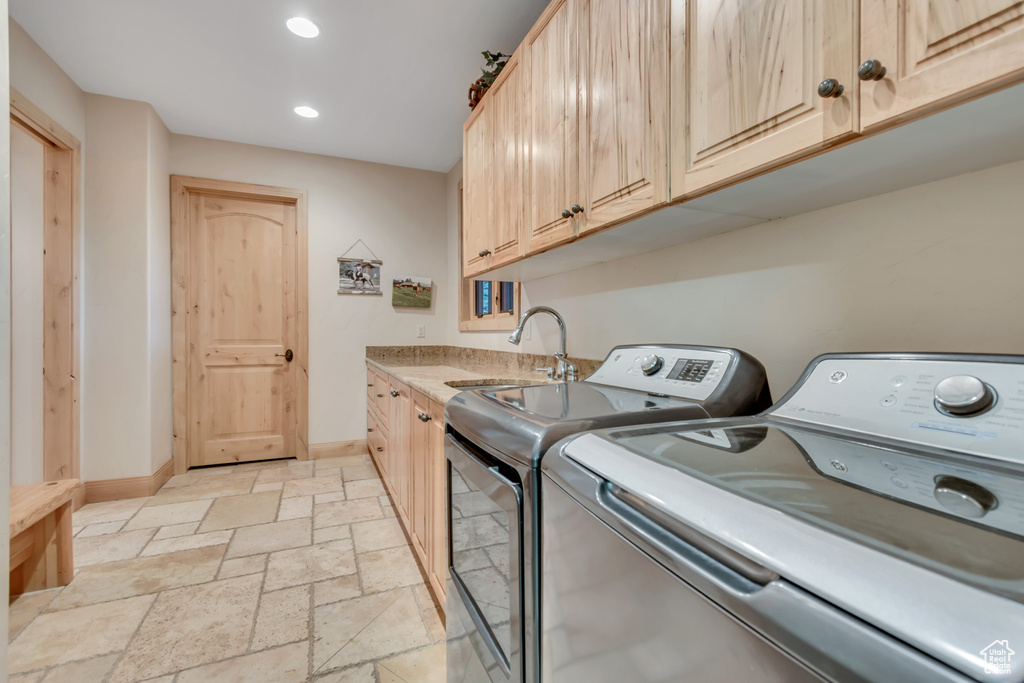 Washroom featuring washing machine and dryer, stone tile floors, cabinet space, and recessed lighting