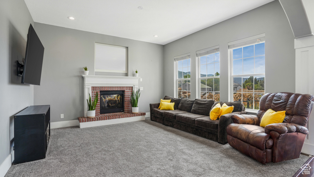 Living room featuring carpet, a brick fireplace, and recessed lighting