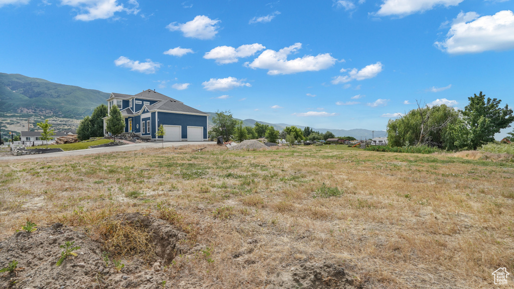 View of yard featuring a mountain view, driveway, and an attached garage