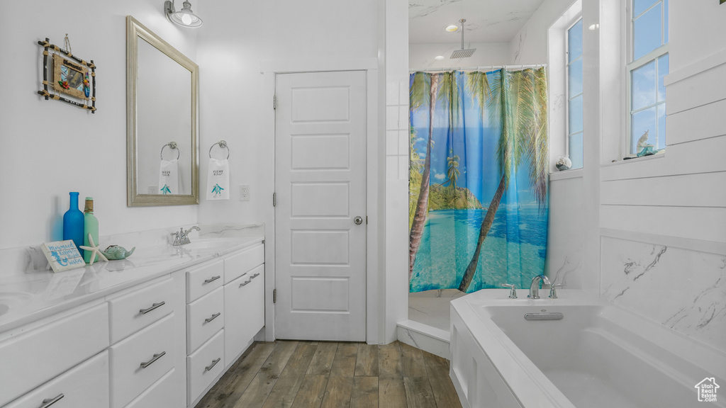 Bathroom with a bath, vanity, wood finished floors, and a shower with shower curtain