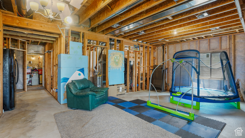 Unfinished basement featuring freestanding refrigerator