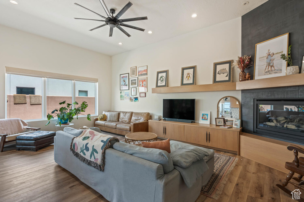 Living room with wood finished floors, ceiling fan, recessed lighting, and a multi sided fireplace