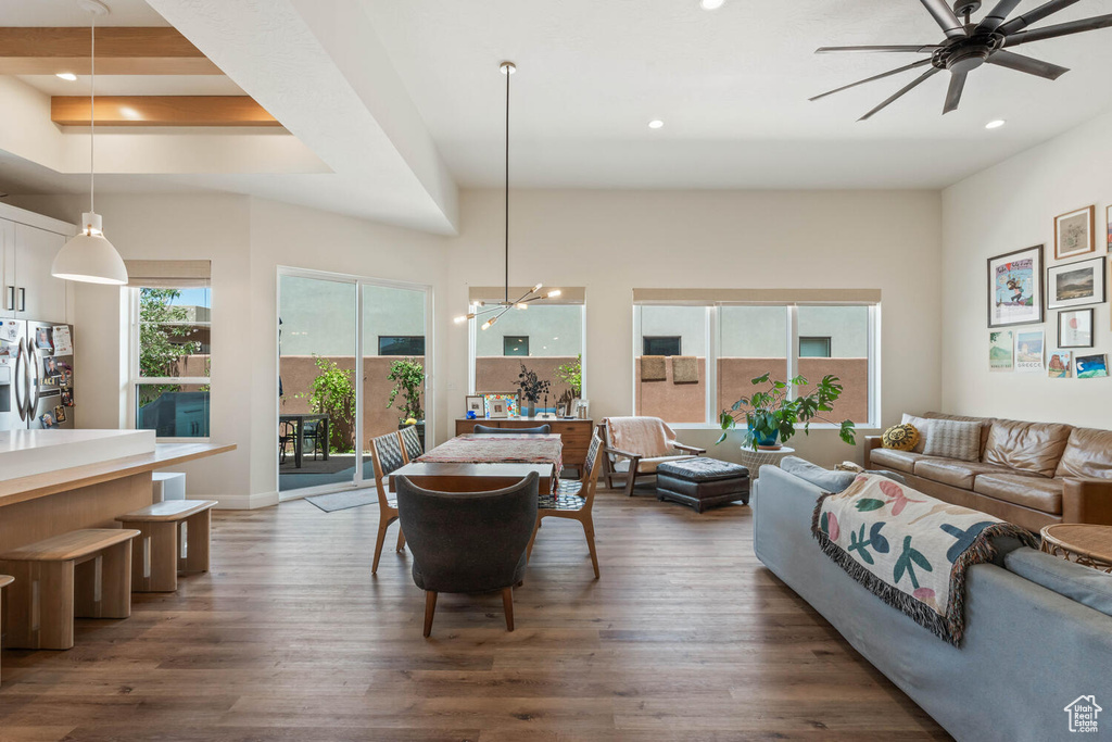Living room with dark wood finished floors, recessed lighting, ceiling fan, and a chandelier