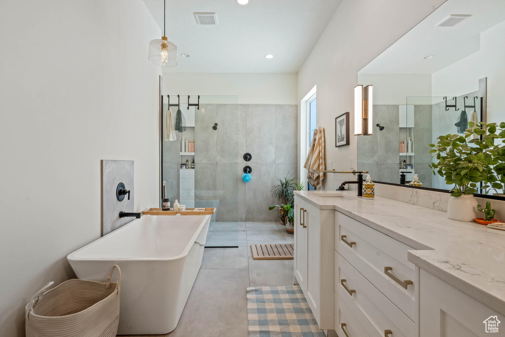 Full bathroom featuring walk in shower, vanity, a freestanding tub, and recessed lighting