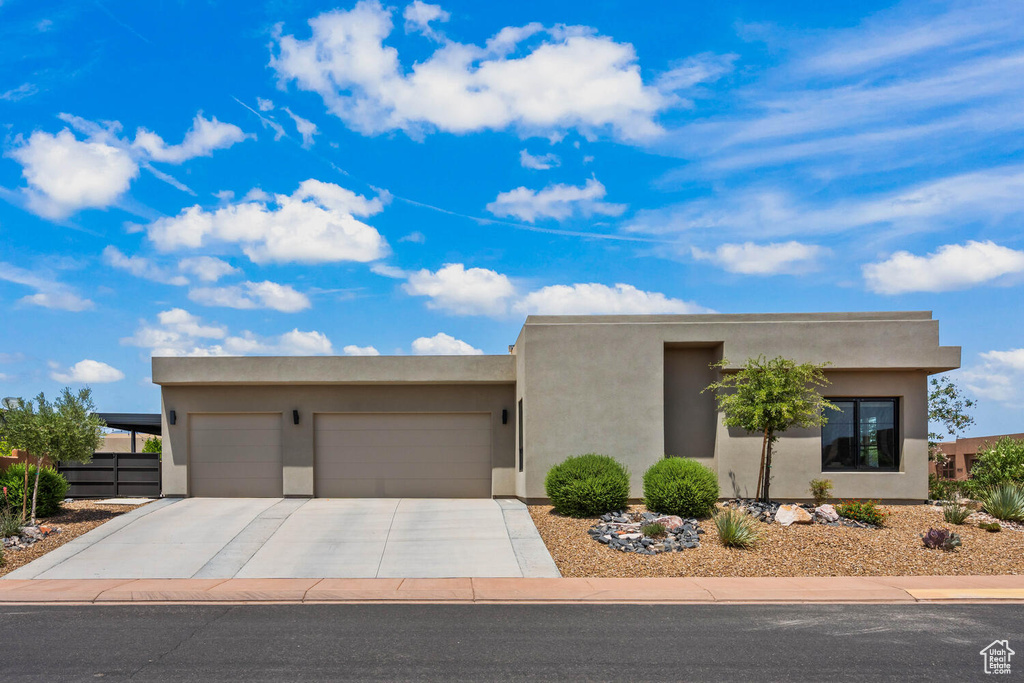 Southwest-style home with an attached garage, concrete driveway, and stucco siding
