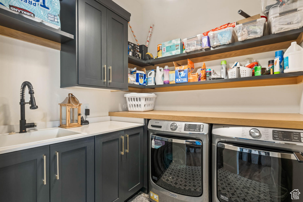 Washroom featuring cabinet space and washer and clothes dryer